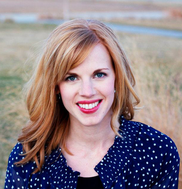 A woman with red hair and blue polka dot shirt.